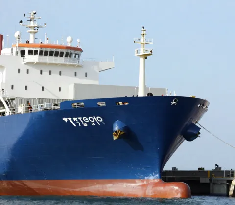 Large cargo shipping vessel docked safely at a port